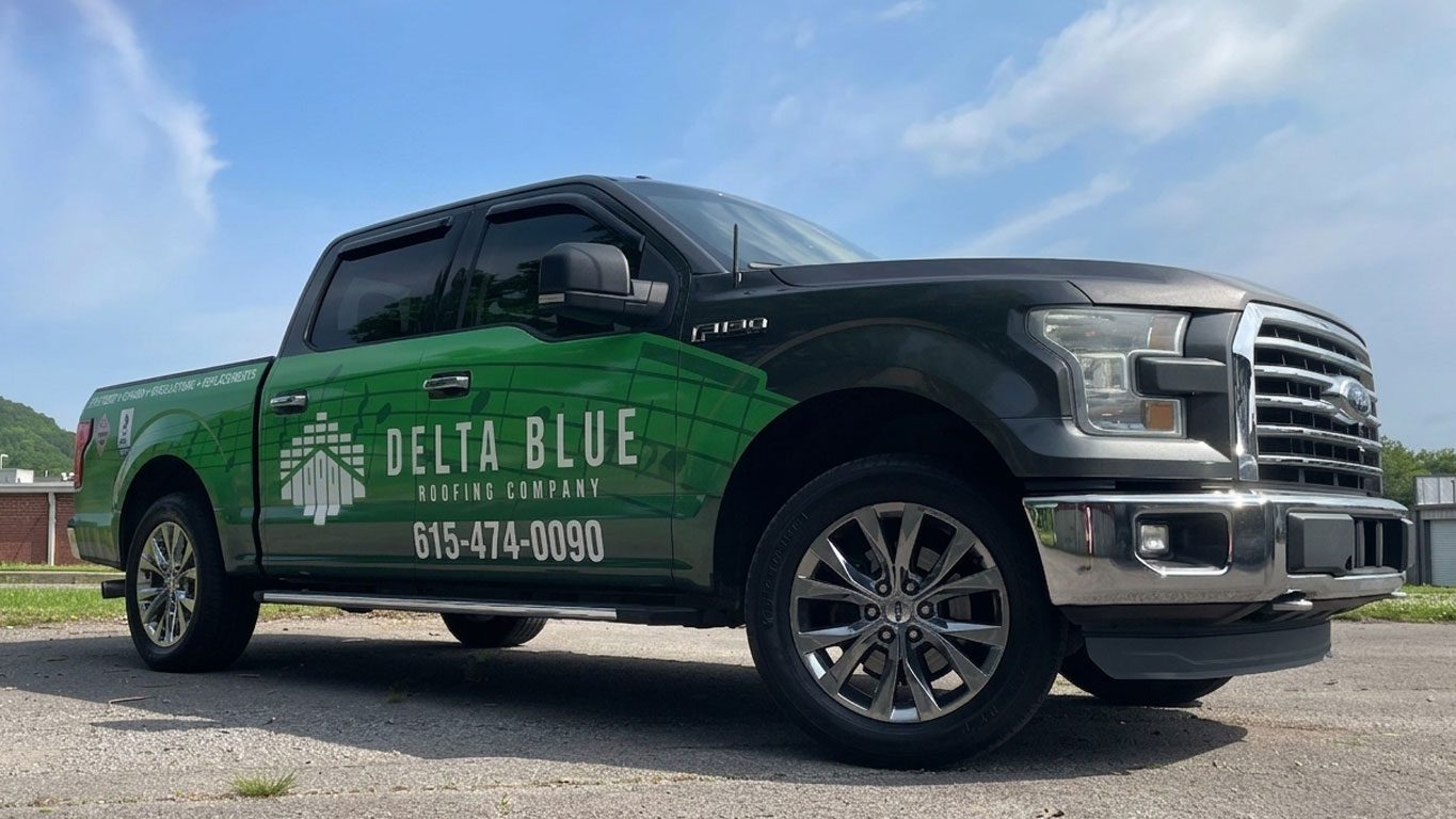 Delta Blue Roofing Company pickup truck with green wrap, logo, and phone number 615-474-0090 parked on a paved lot. | Jerad Schutt | Nashville Marketing Consultant | Fractional CMO | Jerad Schutt | Nashville Marketing Consultant | Fractional CMO
