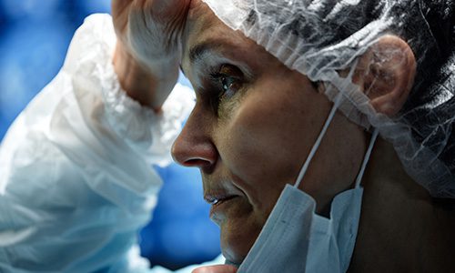 Close-up of a surgeon wearing a disposable cap and mask, focused during a medical procedure. | Jerad Schutt | Nashville Marketing Consultant | Fractional CMO | Jerad Schutt | Nashville Marketing Consultant | Fractional CMO