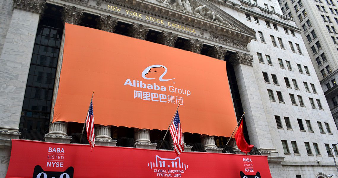 Facade of the New York Stock Exchange with a large orange Alibaba Group banner, flanked by American and Chinese flags, and red banners advertising the 11.11 Global Shopping Festival 2015. | Jerad Schutt | Nashville Marketing Consultant | Fractional CMO | Jerad Schutt | Nashville Marketing Consultant | Fractional CMO